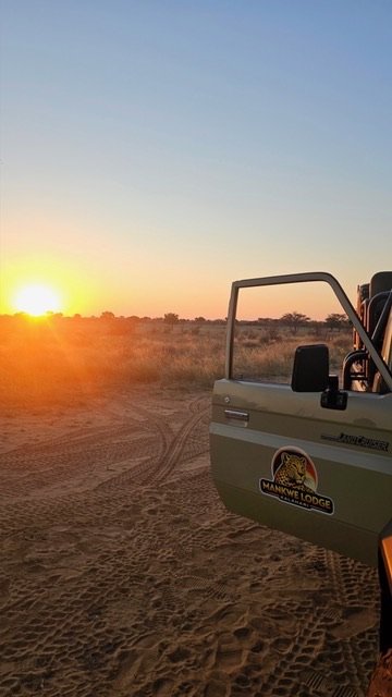Safari vehicle at sunrise in the Kalahari